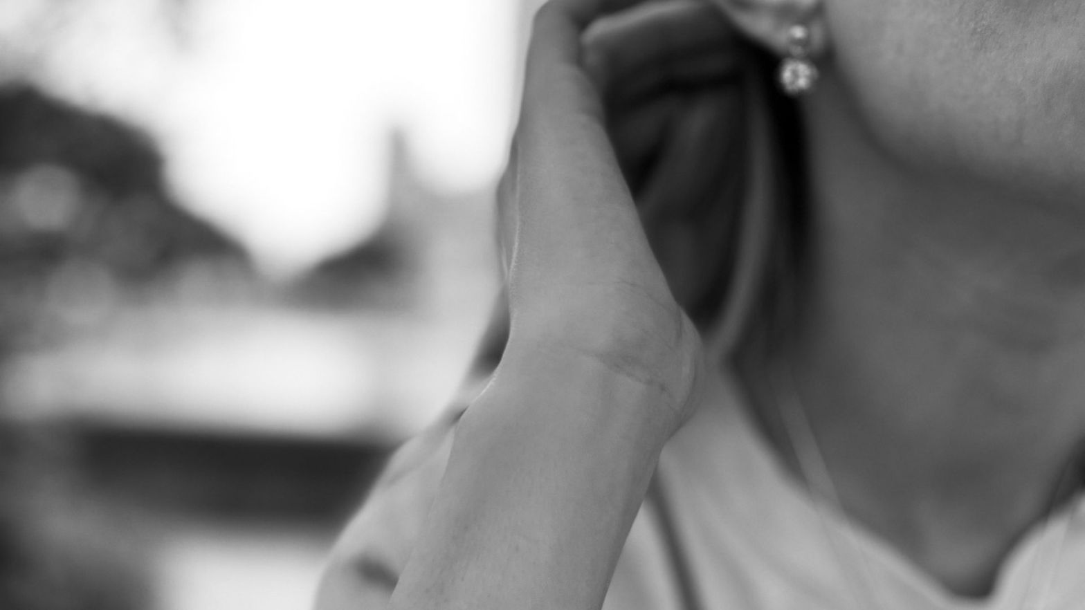 Tetyana is holding her hand behind her ear. The earring is visible as well as the chin, neck, hand, and a bit of a chest. This picture is used for the post "teaching during the war."